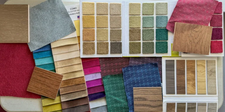 Fabric, wood stain, and carpet samples laid out for a church design consultation